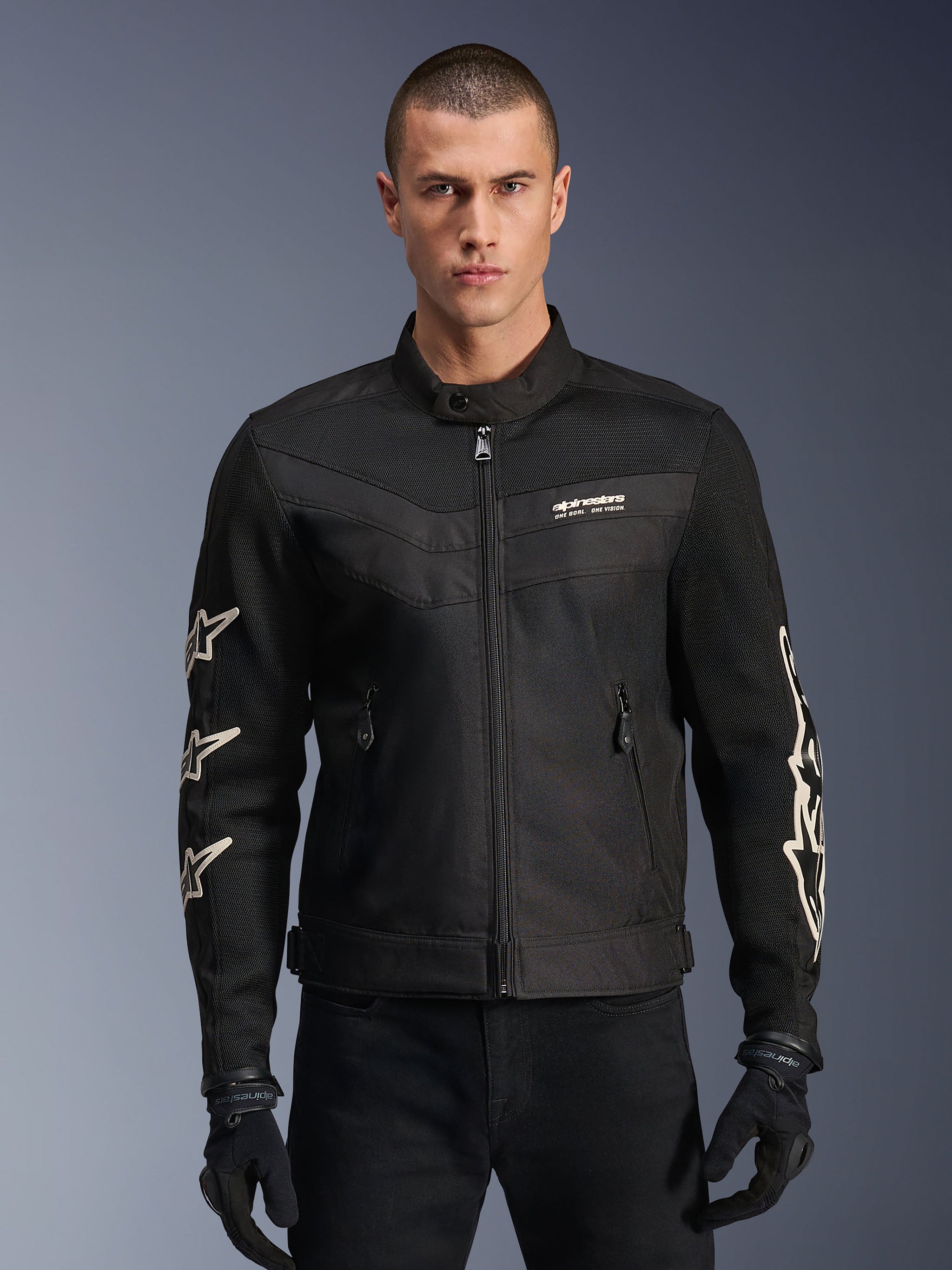 Alpinestars T-Dyno Air Jacket, Black textile motorcycle jacket, featuring white star graphics on sleeves and logo on chest, mesh panels for ventilation, vintage-inspired biker fit, worn with black gloves and pants