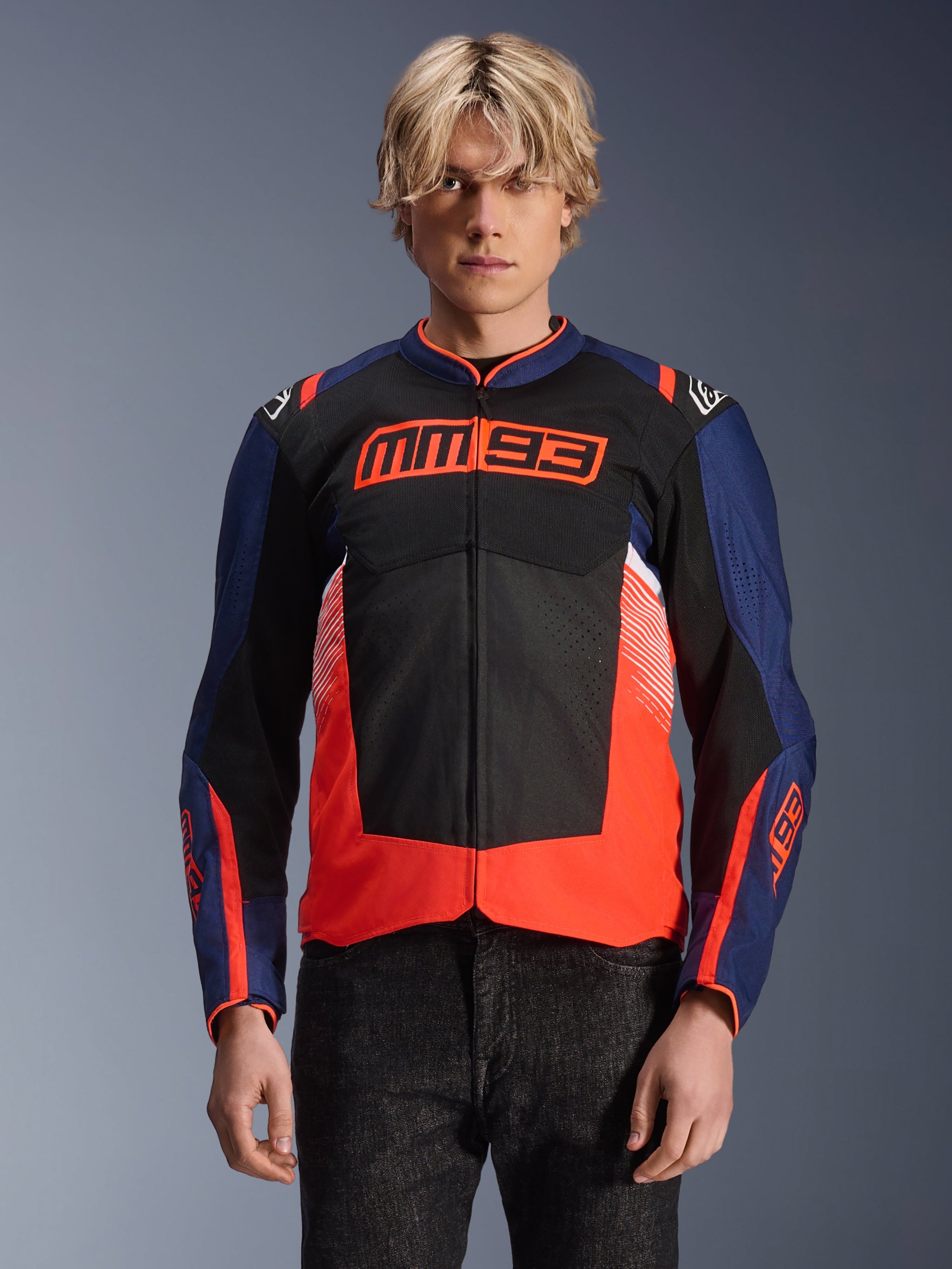 Alpinestars MM93 T-SPS Air V2 Jacket, Textile Motorcycle Jacket, Navy Blue Black and Fluorescent Red, worn by a person, featuring bold MM93 branding on chest, mesh panels for ventilation, and modern color-blocked design
