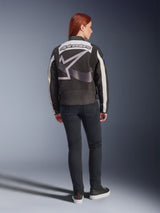 Alpinestars Idles Women’s Jacket, Urban Motorcycle Jacket, Black and Off-White, back view featuring a large grey Alpinestars logo and wordmark, worn with slim-fit black jeans and sneakers, vintage-inspired design for urban riding