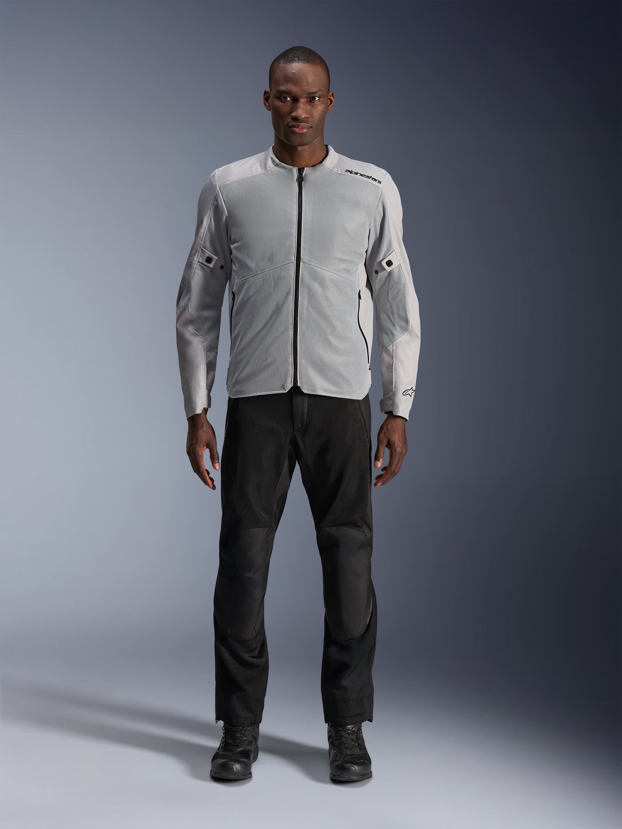 Alpinestars C-1 Air Jacket in Silver, men's urban textile motorcycle jacket with ventilated mesh panels, worn by a model with black riding pants and black boots, contemporary commuting style