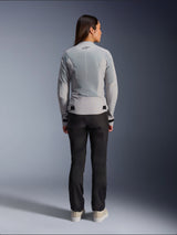 Woman wearing Alpinestars Stella C-1 Air Jacket in Silver, back view, featuring large tech mesh panels for ventilation and a reflective star logo, paired with black riding pants and white sneakers, urban contemporary motorcycle gear