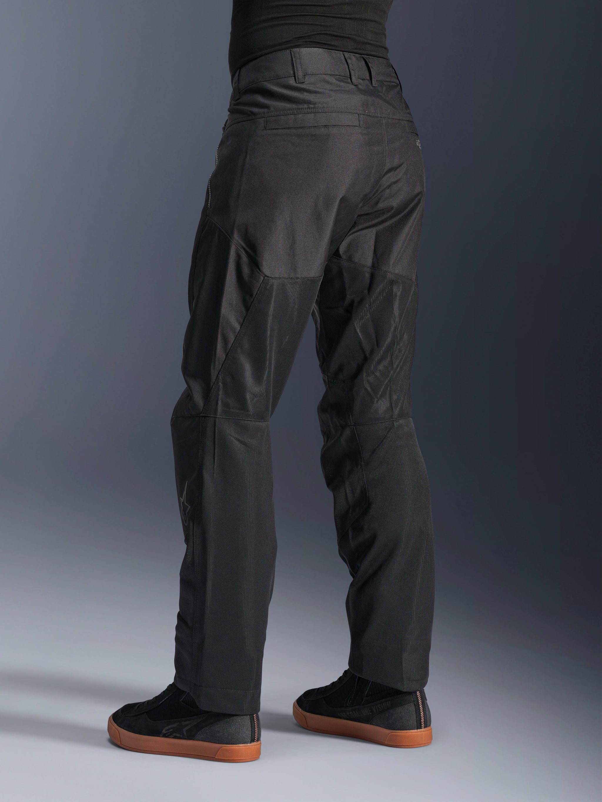 Alpinestars C-1 Air Pants, Urban Motorcycle Pants, Black, rear view showing large tech mesh panels on the back of the legs for ventilation, clean styling for city riding, worn with casual black sneakers.