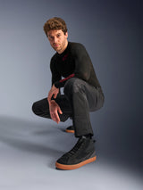Alpinestars C-1 Air Pants, Urban Motorcycle Pants, Black, model crouching in a studio setting, worn with a black long-sleeve top and black sneakers with tan soles, featuring breathable mesh panels and a contemporary urban style