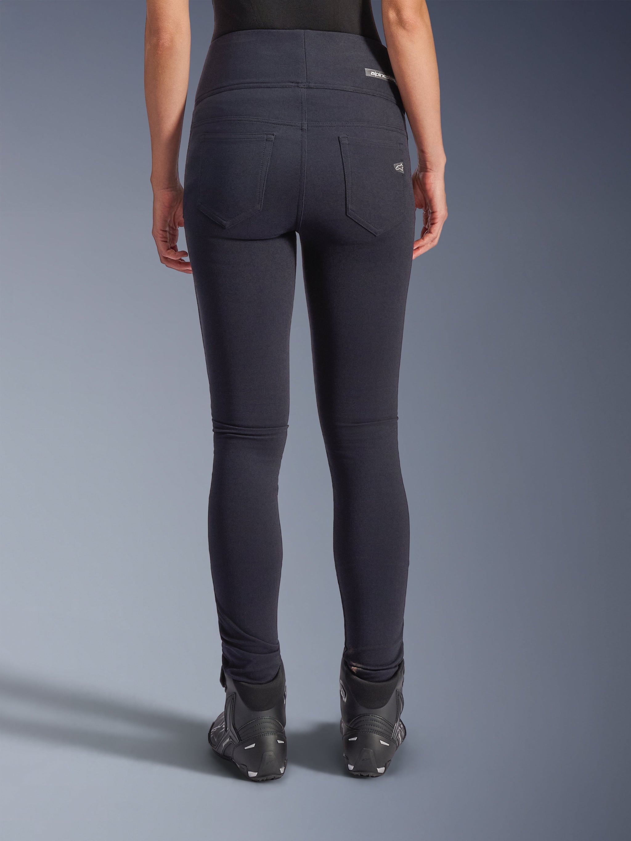 Alpinestars Stella Flex-AST Leggings, Urban Motorcycle Pants, Black, back view featuring high-waisted skinny fit, two functional back pockets with subtle branding, stretch textile material, worn with black riding shoes.