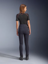 Alpinestars Stella Flex-AST Leggings in Black, women's high-waisted motorcycle pants, back view showing skinny fit and rear pockets, worn with black short-sleeve top and riding boots, urban riding gear