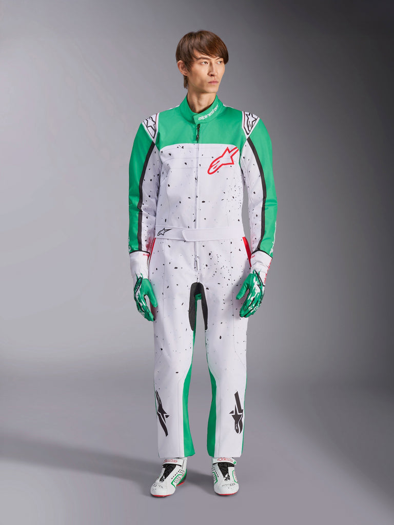 Alpinestars KMX-9 V3 Graphic 6 Suit, White Green and Red, one-piece karting suit featuring a black splatter graphic pattern, green panels on sleeves and legs, red Alpinestars chest logo, worn with matching racing gloves and shoes