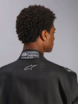 Alpinestars Hypertech V3 Suit, Black Dark Shadow, close-up rear view of the collar with FIA 8856-2018 certification label and back logo, professional lightweight racing suit with athletic fit