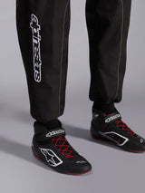 Alpinestars KMX-9 V3 Suit, Karting Suit, Black Red and White, detail view of lower legs and karting boots, white Alpinestars branding on the side, black shoes with red laces and white accents, professional motorsport racing gear.