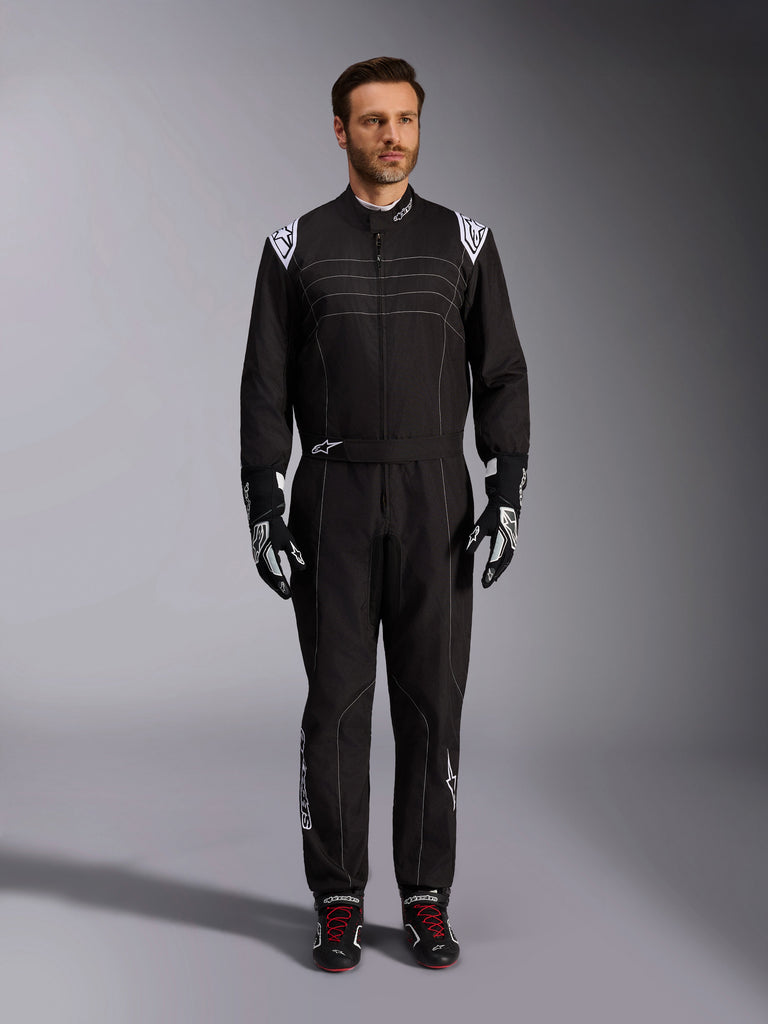 Alpinestars KMX-9 V3 Suit, Black and White Karting Suit, full-length view on a model, featuring white shoulder logos and accents, styled with black and white racing gloves and black shoes with red laces, athletic-regular fit for professional karting gear.