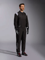 Alpinestars KMX-9 V3 Karting Suit, Black and White, male model wearing full racing suit with white Alpinestars logo on epaulettes, paired with black and white racing gloves and black karting shoes with red laces, studio shot showing the front and side profile