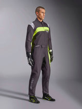 Male model wearing Alpinestars KMX-9 V3 Graphic 3 Suit in Black and Yellow Fluo, professional karting gear with vibrant neon yellow panels and white logo accents, accessorized with coordinated racing gloves and shoes, set against a studio background.