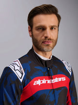 Alpinestars KMX-9 V3 Graphic 5 Suit, Karting Suit in Navy Red, featuring a blue and black camouflage graphic pattern, bold red horizontal stripe with white alpinestars text across the chest, and white logos on the shoulders, worn by a model in a studio setting.