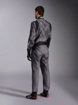 Alpinestars KMX-9 V3 Graphic 5 Suit, Dark Gray and Black Karting Suit, rear view of model wearing full racing kit including black and red gloves and karting shoes, featuring integrated graphic patterns and branding on the back.
