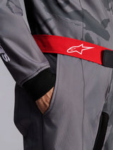 Alpinestars KMX-9 V3 Graphic 5 Suit, Karting Suit, Dark Gray and Black with Red belt, close-up featuring red adjustable waist belt with white logo, hand in thigh pocket, and black knitted cuff on gray graphic patterned fabric