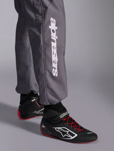 Alpinestars KMX-9 V3 Graphic 5 Suit, Karting Suit, Dark Gray, close-up of lower leg featuring white vertical Alpinestars logo, worn with black and red racing shoes, durable material for karting competition