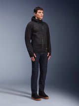 Alpinestars MO.ST.EQ Hybrid Hooded Jacket, black mid-season padded hoodie with an angled front zipper, worn by a male model with dark blue jeans and black sneakers, urban contemporary motorcycle gear.