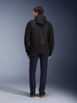Alpinestars MO.ST.EQ Hybrid Hooded Jacket, Black, rear view showing seamless padded back panel with tonal embossed Alpinestars logo, worn with dark jeans and black sneakers, urban motorcycle streetwear.
