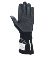 Alpinestars Tech-1 ZX V4 Gloves, Black Anthracite, palm view featuring textured 3D silicone grip, long cuff with FIA and SFI safety certification labels, professional auto racing gloves