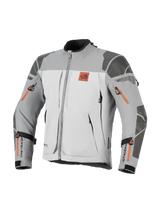 Alpinestars Nazca 3L GORE-TEX PRO Jacket, Adventure Motorcycle Jacket, Dark Gray and Mid Gray with orange zipper accents, featuring All Terra chest logo, Superfabric reinforcements on shoulders and elbows, multiple zippered ventilation openings, rugged touring design