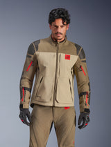 Alpinestars Nazca 3L GORE-TEX PRO Jacket, adventure motorcycle touring jacket, Walnut Rock Brown and beige with red accents, featuring black Superfabric shoulder reinforcements and red sleeve zippers, worn by rider with matching gear, premium technical adventure outerwear