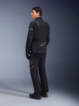 Alpinestars ST-7 2L GORE-TEX Pants, Adventure Touring Pants, Black and Dark Gray, worn with matching ST-7 jacket and black boots, featuring 'Alpinestars Exploration Equipment' branding on the thigh, designed for waterproof and breathable four-season riding.