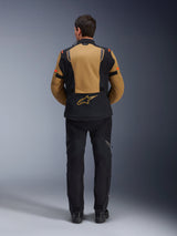 Alpinestars ST-7 2L GORE-TEX Jacket, Adventure Motorcycle Jacket, Gobi Brown and Black, back view showing ergonomic paneling and Alpinestars logo, worn with black riding pants and boots, waterproof touring gear