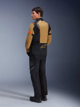 Alpinestars ST-7 2L GORE-TEX Jacket, Adventure Motorcycle Jacket, Gobi Brown and Black, rear view on a model wearing matching riding pants and boots, featuring orange sleeve accents, waterproof laminated shell, and Alpinestars logo, designed for touring and road riding