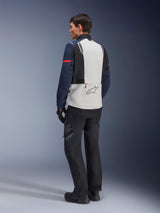 Model wearing Alpinestars ST-7 2L GORE-TEX Jacket in Ice Gray Dark Blue and Black, rear view, light gray back panel with Alpinestars logo, dark blue sleeves with red stripe, paired with black adventure riding pants and boots, motorcycle touring gear
