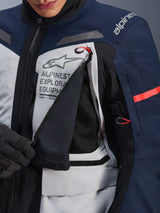 Alpinestars ST-7 2L GORE-TEX Jacket, Adventure Touring Jacket, Ice Gray Dark Blue and Black, detailed view of the unzipped chest ventilation panel revealing black mesh, featuring Alpinestars Exploration Equipment logo and red accent pull tabs