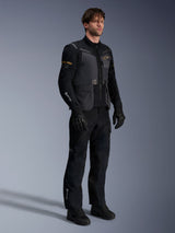 Male model wearing the Alpinestars ST-7 2L GORE-TEX Jacket in Deep Gray Black and Dark Khaki, paired with matching black adventure pants and gloves, featuring waterproof laminated shell with cargo pockets and technical branding, ideal for adventure touring.