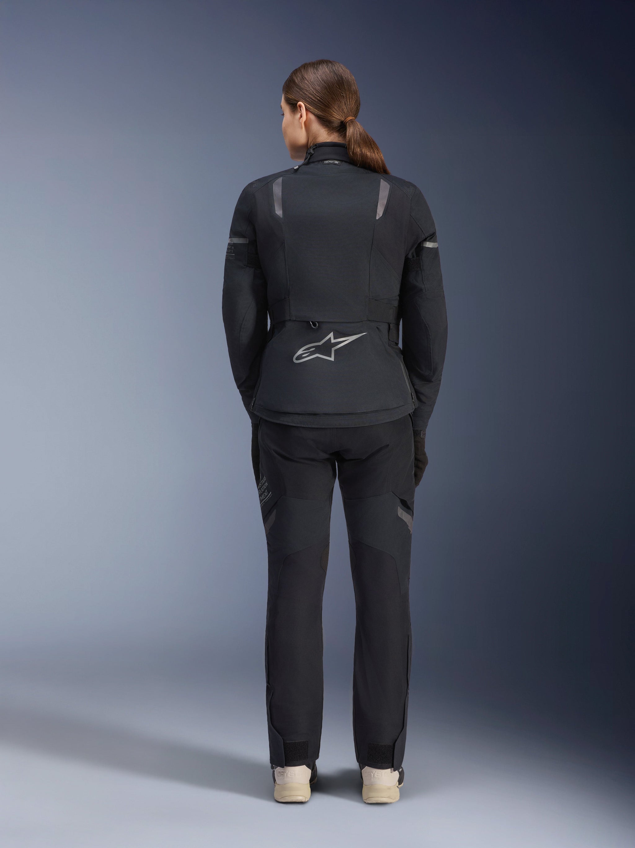 Alpinestars Stella ST-7 2L GORE-TEX Jacket and Pants, Women's Motorcycle Adventure Touring outfit, Black and Dark Gray, back view showing the Astar logo and reflective details, durable waterproof textile construction