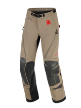 Alpinestars Nazca 3L GORE-TEX PRO Pants, Adventure Motorcycle Pants, Walnut and Black, featuring a red All Terra logo patch, GORE-TEX PRO branding, black Superfabric knee and shin reinforcements, zippered thigh ventilation, and an integrated belt with a magnetic buckle.