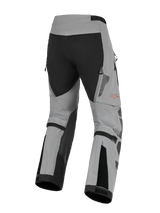 Alpinestars Nazca 3L GORE-TEX PRO Pants, Adventure Motorcycle Riding Pants, Dark Gray and Black, rear view showing calf volume adjusters and zippered exhaust vents, durable textile construction with a red Alpinestars logo on the leg