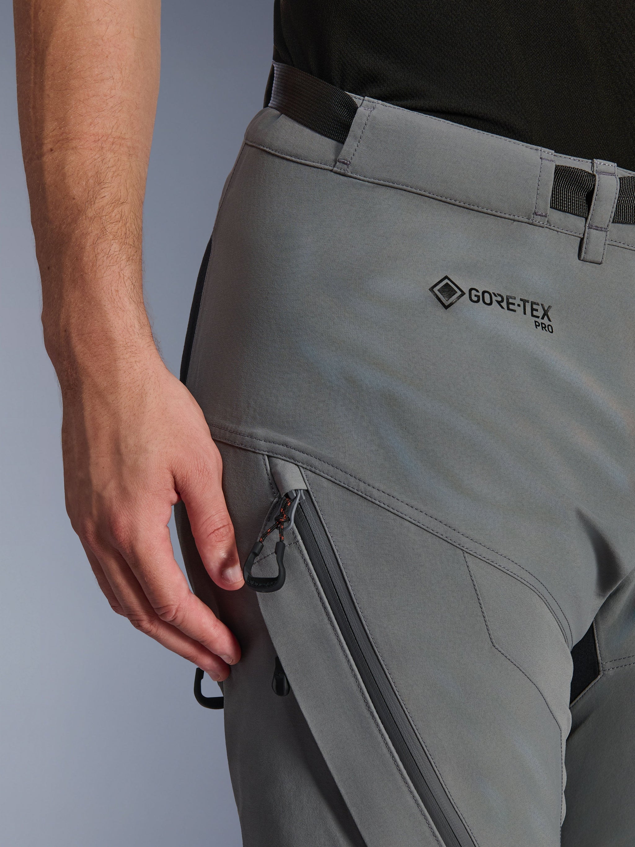 Close-up of Alpinestars Nazca 3L GORE-TEX PRO Pants in Dark Gray Black, showing the GORE-TEX PRO branding on the hip, a zippered water-resistant cargo pocket, and durable textile construction for adventure riding.
