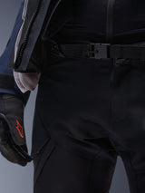Alpinestars ST-7 2L GORE-TEX Pants, Black, close-up of the waist featuring a magnetic buckle closure and durable technical textile construction, worn with matching adventure touring jacket and black gloves with a red logo.