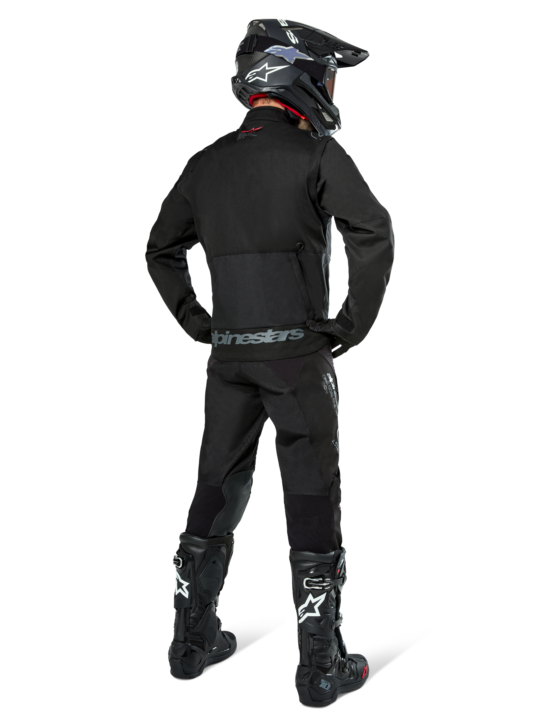 Alpinestars Pro-Dura Jacket, Black Off-road Enduro Jacket, rear view worn with matching pants and black Tech 10 boots, featuring prominent Alpinestars branding on the lower back, rugged textile construction for aggressive trail riding