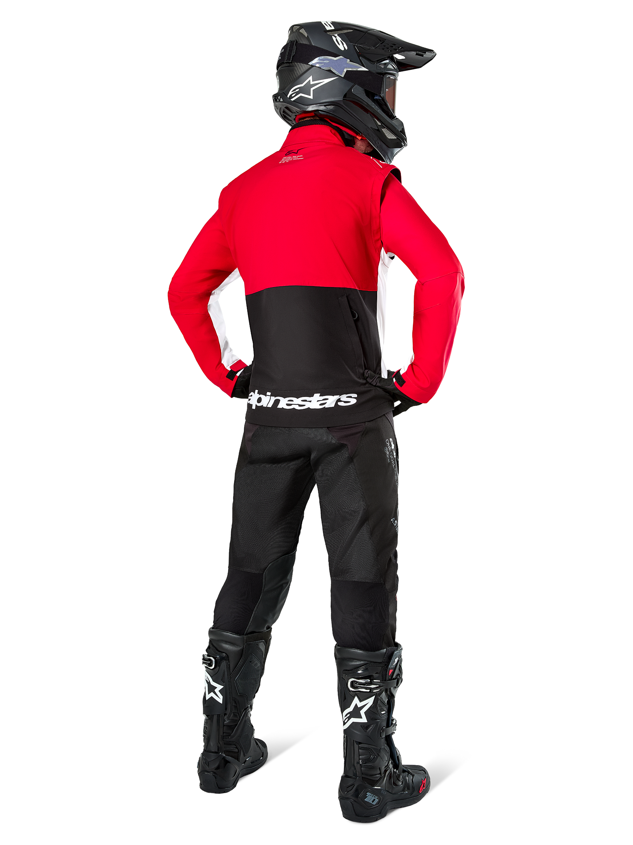 Motocross rider from behind wearing Alpinestars Lite-Dura Softshell Jacket, Black Bright Red and White, featuring a red upper panel and black lower section with white branding, paired with black pants, black helmet, and black boots, coordinated enduro outfit for off-road riding