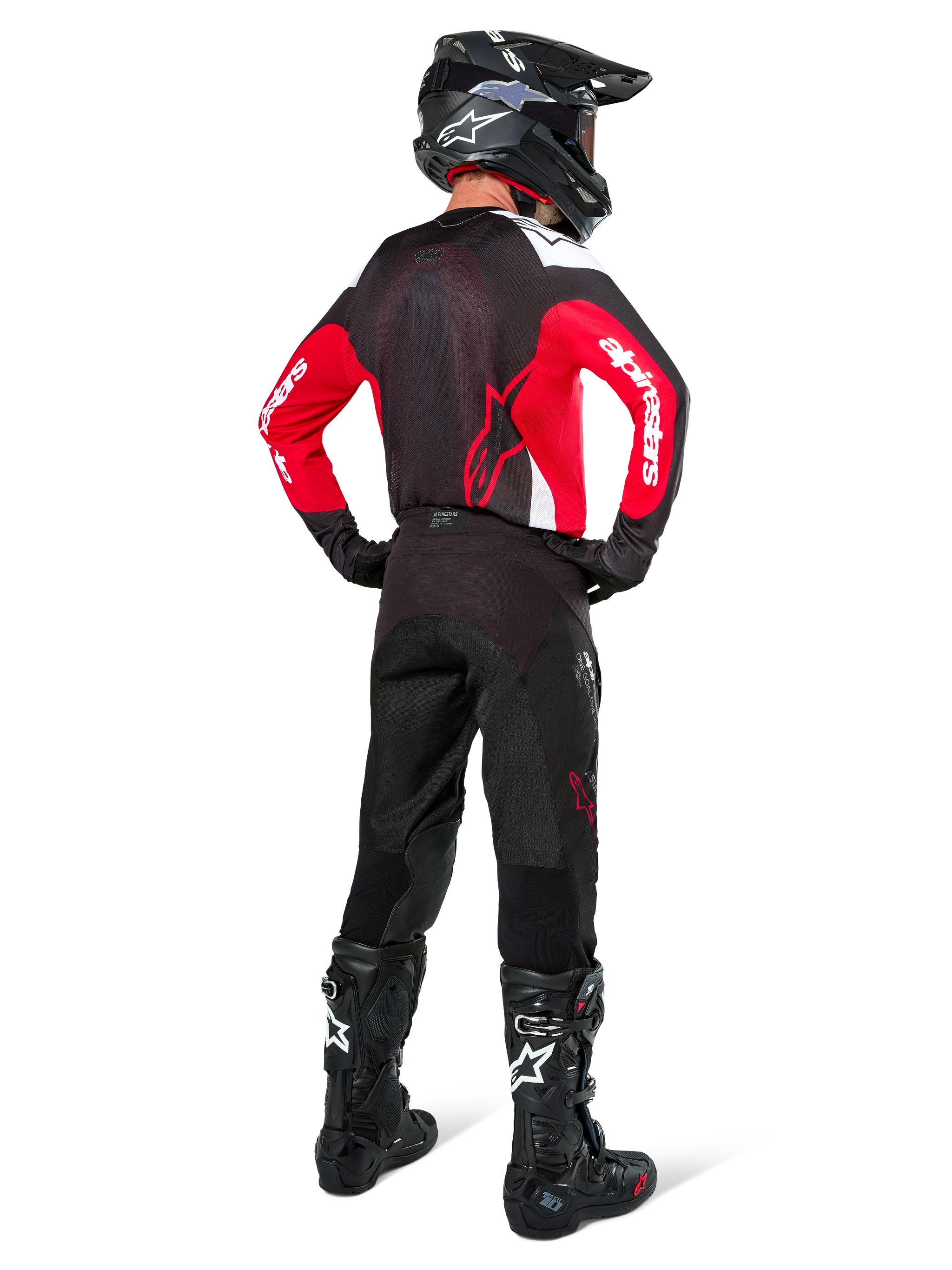 Motocross rider from behind wearing Alpinestars Pro-Dura Pants in Black Magnet White, paired with a red and black jersey and black boots, coordinated off-road gear set for enduro riding