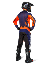 Motocross rider wearing complete racing gear from the back, Navy and orange jersey, Pro-Dura Pants in Navy Hot Orange White, black helmet and black boots, professional off-road racing outfit ensemble.