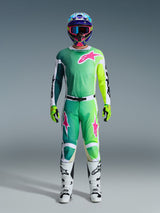 Alpinestars 2026 Racer Portl Pants, Motocross Pants, Green White and Black with pink logo accents, worn as part of a complete racing gear set with a matching jersey, white boots, and a multi-colored helmet, coordinated outfit for professional off-road racing.