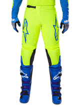 Alpinestars 2025 Fluid Haul Pants, Motocross Pants, Bright Yellow and Blue, worn with matching gloves and boots, featuring black inner knee panels, bold blue branding on the thighs, and a sporty ergonomic design.