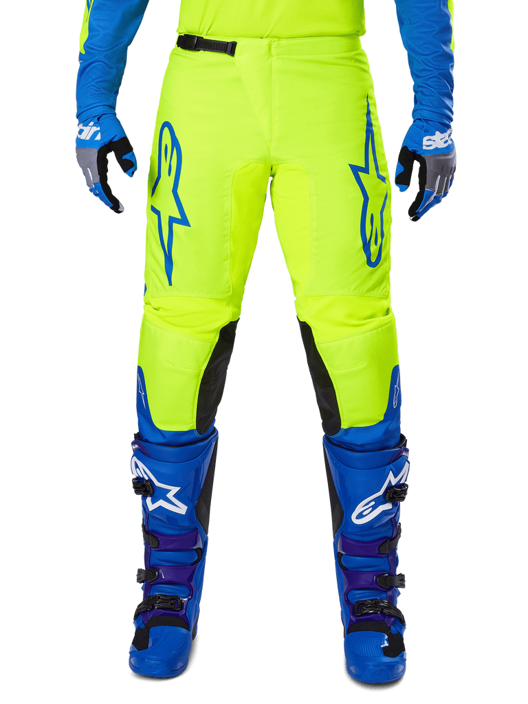 Alpinestars 2025 Fluid Haul Pants, Motocross Pants, Bright Yellow and Blue, worn with matching gloves and boots, featuring black inner knee panels, bold blue branding on the thighs, and a sporty ergonomic design.