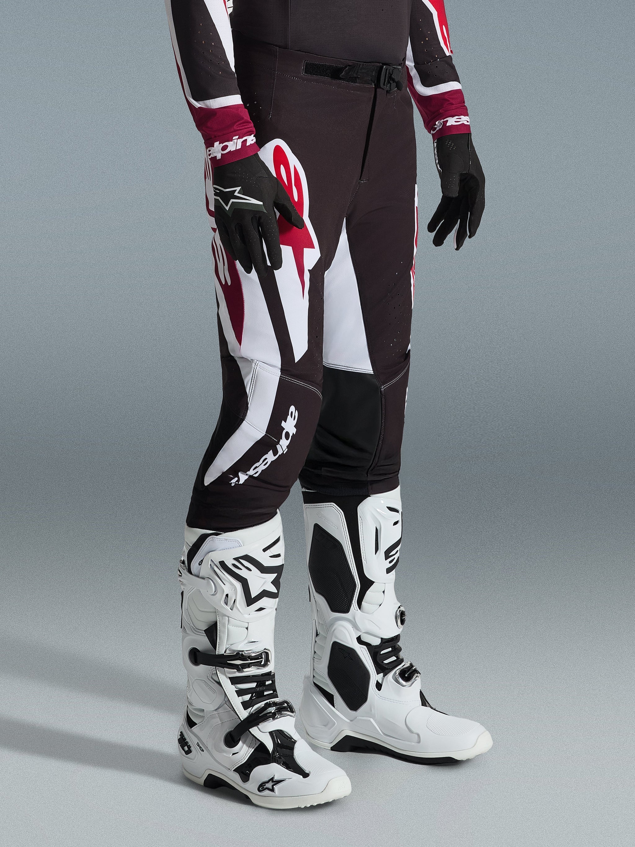Alpinestars 2026 Supertech AFD Vista Pants, Motocross Pants, Black Red and White, worn with white and black motocross boots and black gloves, featuring large white and red graphic patterns, athletic race fit design