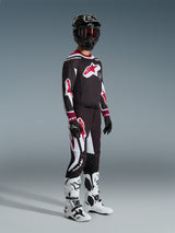 Alpinestars 2026 Supertech AFD Vista Pants, Motocross Pants, Black Red and White, worn with matching racing jersey, black helmet with red goggles, black gloves, and white boots, athletic performance gear for off-road racing