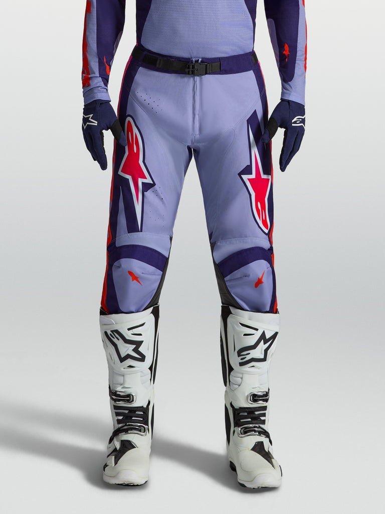 Alpinestars Racer Air Hunt Motocross Pants in light violet and deep purple with pink fluo accents, worn with white boots.