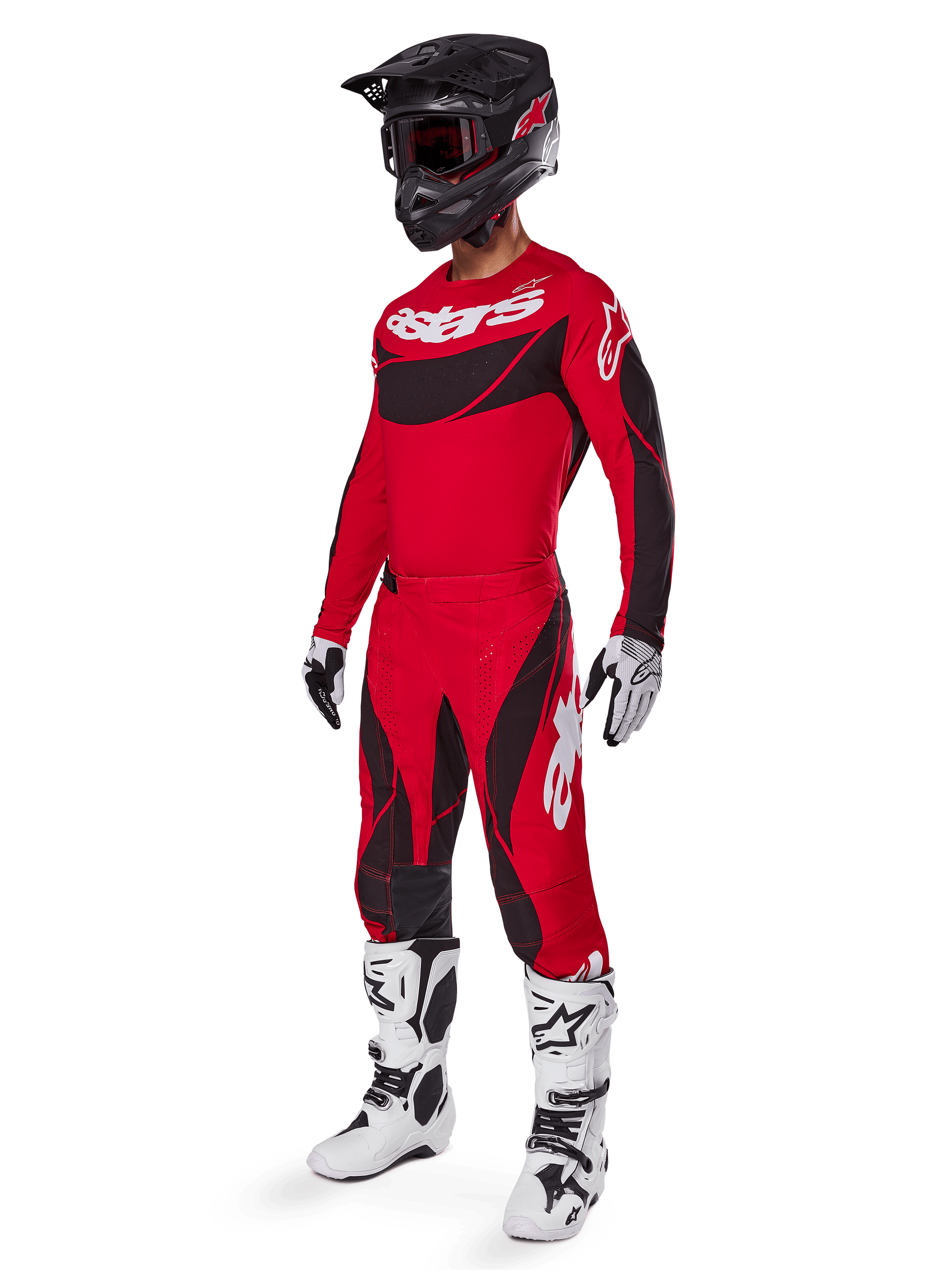 Motocross rider wearing complete racing gear featuring Alpinestars 2025 Techstar Dreem Pants in Bright Red and Black, matching red and black jersey with white logo, black helmet, and white and black boots, coordinated outfit for off-road racing