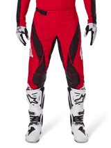 Alpinestars 2025 Techstar Dreem Pants, Motocross Pants, Bright Red and Black, featuring angular patterns and laser-cut ventilation holes, worn with white motocross boots and matching gloves for off-road racing