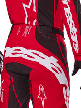 Alpinestars 2025 Techstar Dreem Pants, Motocross Pants, Bright Red and Black, close-up of the rear waist and seat area featuring bold white Alpinestars branding, black stretch panels, and technical production text on the waistband, designed for off-road racing performance.