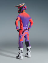 Alpinestars 2026 Supertech Scenz Pants, Motocross Pants, Hot Coral and Purple, rear view showing bold branding on the seat, worn by a rider with a matching jersey and white boots, professional off-road racing gear.