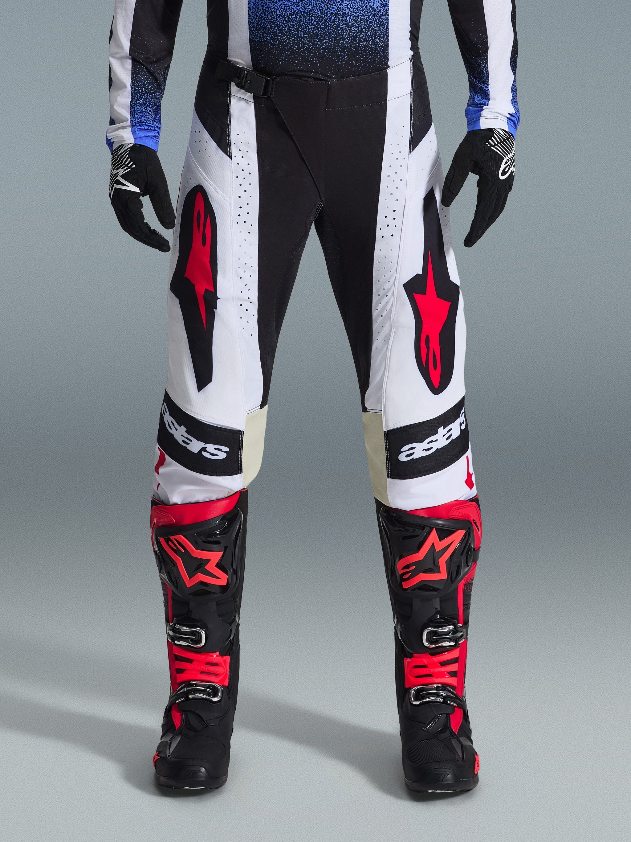 Alpinestars 2026 Techstar Knif Pants, Motocross Pants, Black White and Red, worn with matching red and black boots and black gloves, featuring prominent red star logos on white panels and technical perforated details for off-road racing.